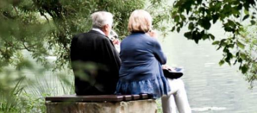 senior couple sitting together on park bench